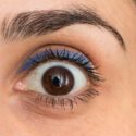 Et vidtåbent kvindeøje med makeup på øjenlågene.