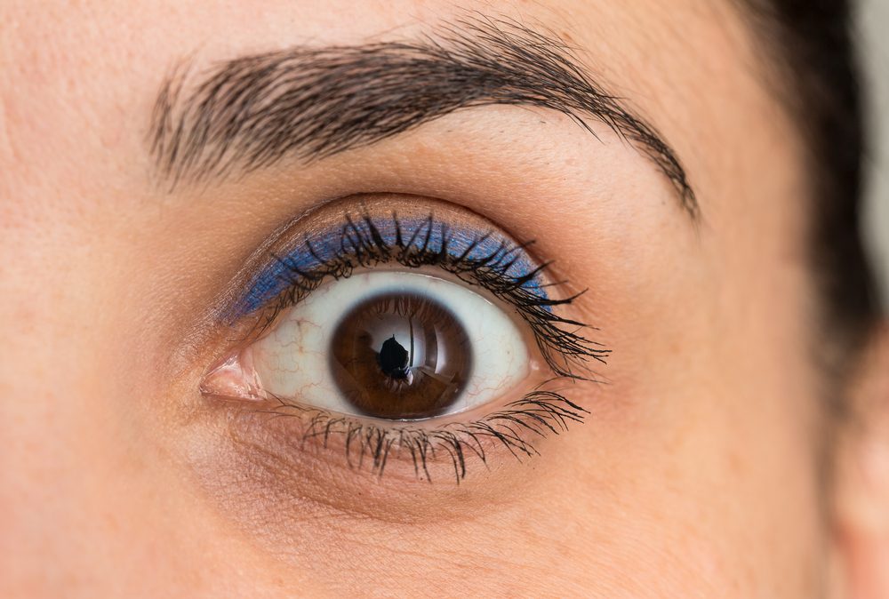 Et vidtåbent kvindeøje med makeup på øjenlågene.