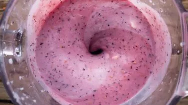 Nærbillede af rød smothie i en blender.