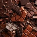 En masse knækket mørk og lys chokolade i en stor bunke.