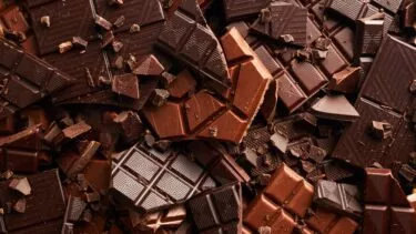 En masse knækket mørk og lys chokolade i en stor bunke.