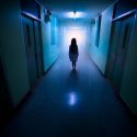 Mareridtsagtig scene, lille pige står alene i en lang, uhyggelig hospitalsgang