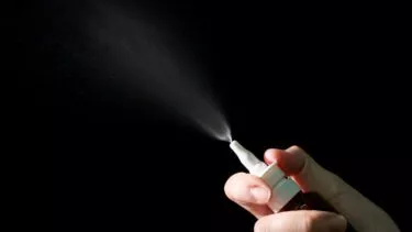 Illustrativt billede af næsespray, der sender partikler ud i luften
