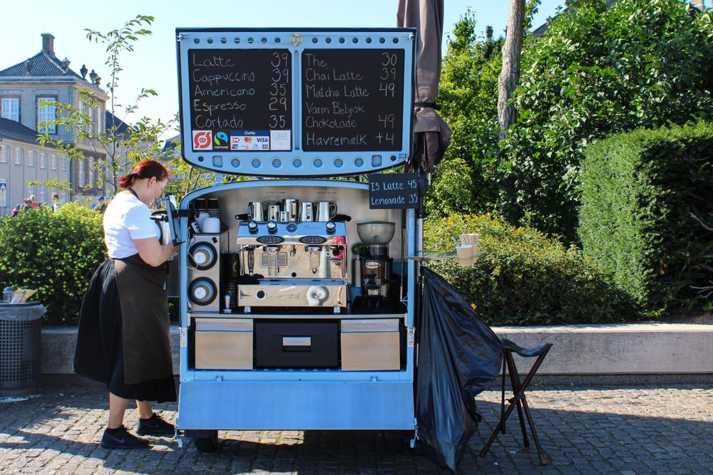 En kaffesælger har sin lille kaffevogn. Hun sælger kaffen i København på en sommerdag.