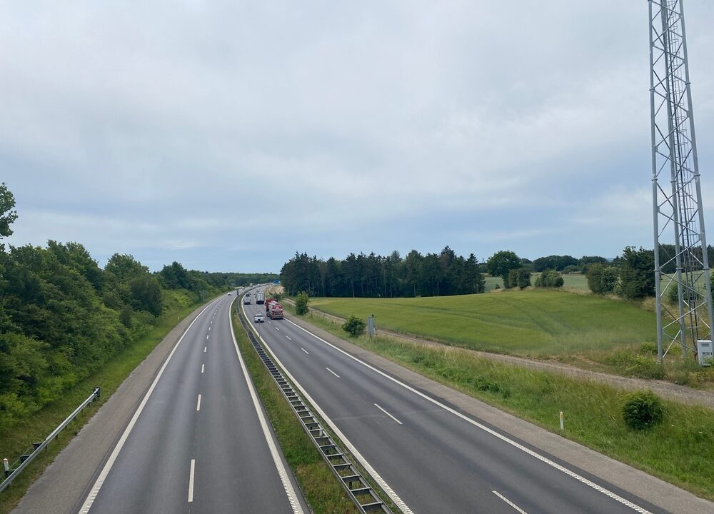 Et billede af en motorvej i Danmark set ovenfra med marker omkring.