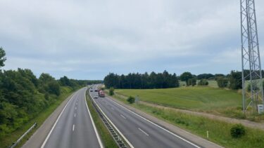 Et billede af en motorvej i Danmark set ovenfra med marker omkring.