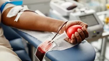 Bloddonor er ved at blive tappet - de har en rød stressbold i hånden