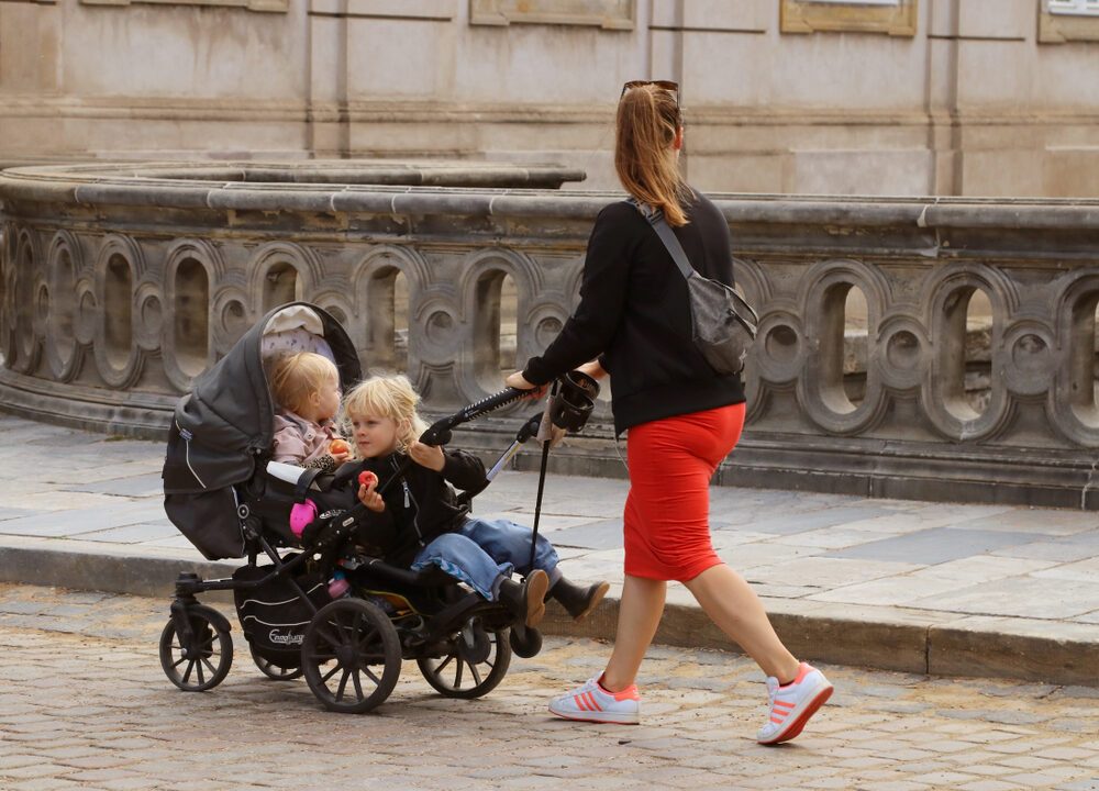 Mor går tur med sine børn i barnevogn på bro ved Christiansborg i København