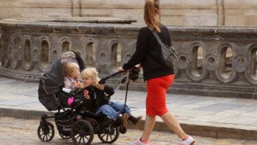 Mor går tur med sine børn i barnevogn på bro ved Christiansborg i København