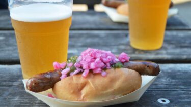 En hotdog og en øl på et bord