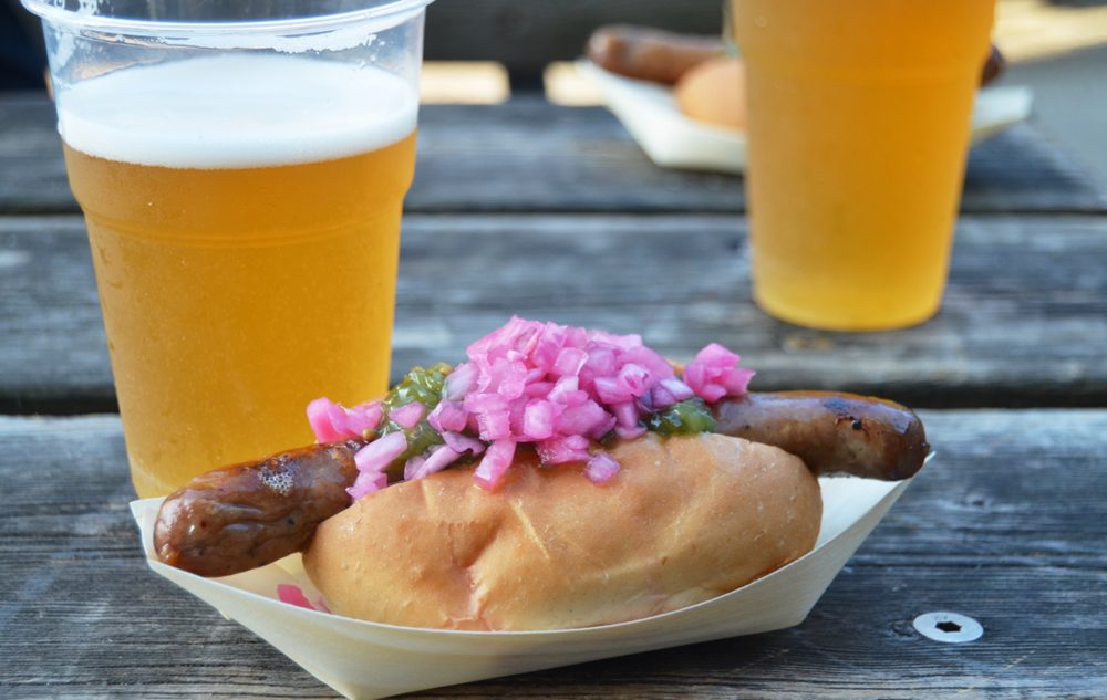 En hotdog og en øl på et bord