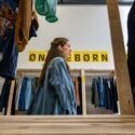 En kvinde går forbi et skilt i et tøjbutik, hvor der står 'ønskebørn'