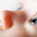 Nærbillede af en babys ansigt. Spædbarnet kigger intenst op mod loftet.