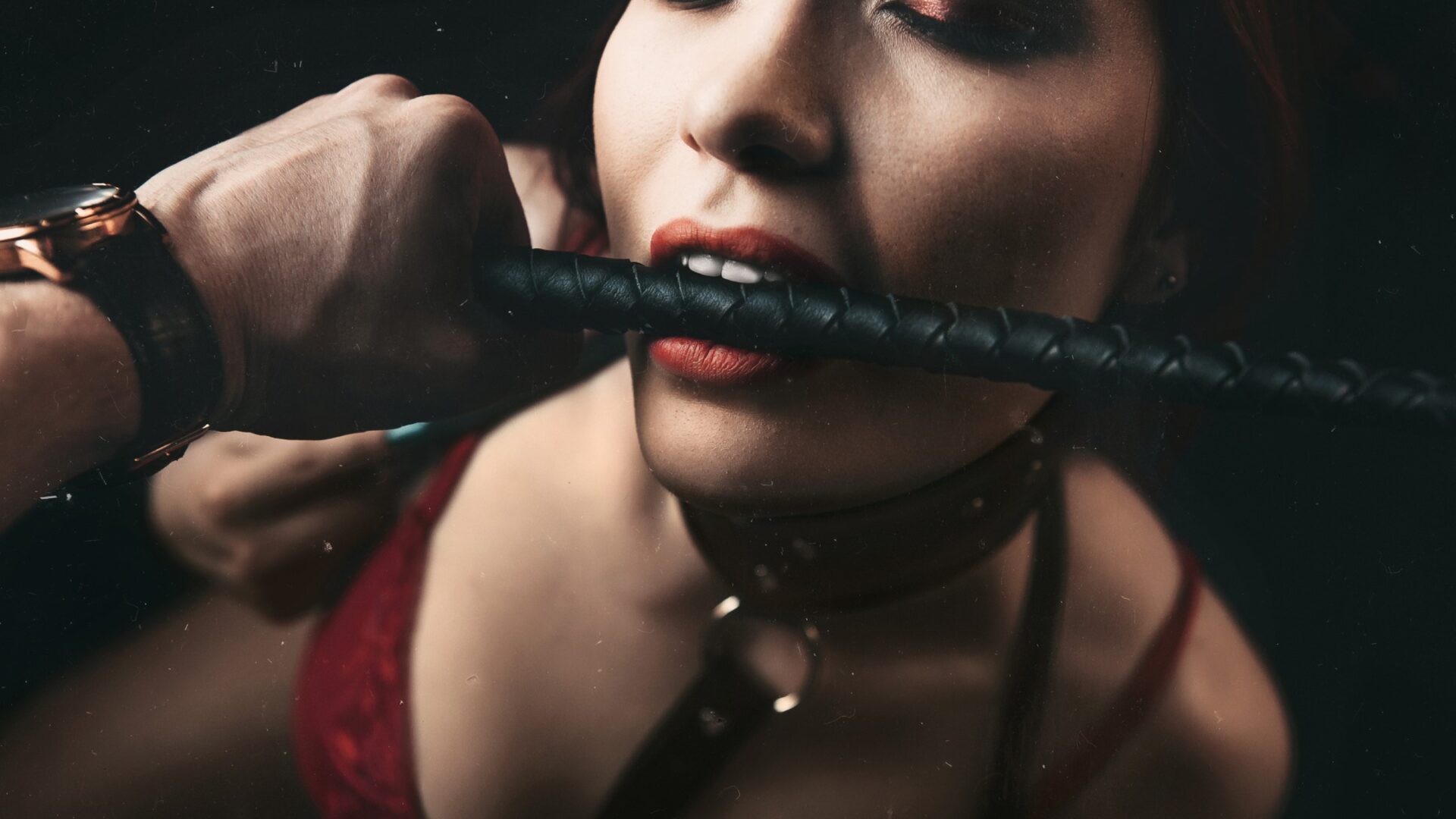 Kvinde udøver BDSM med pisk i munden