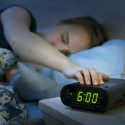 kvinde trykker pa snooze knap om morgenen