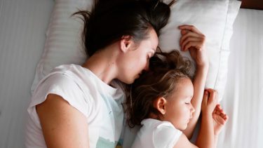 Mor sover sammen med sit barn i en lille seng - de samsover