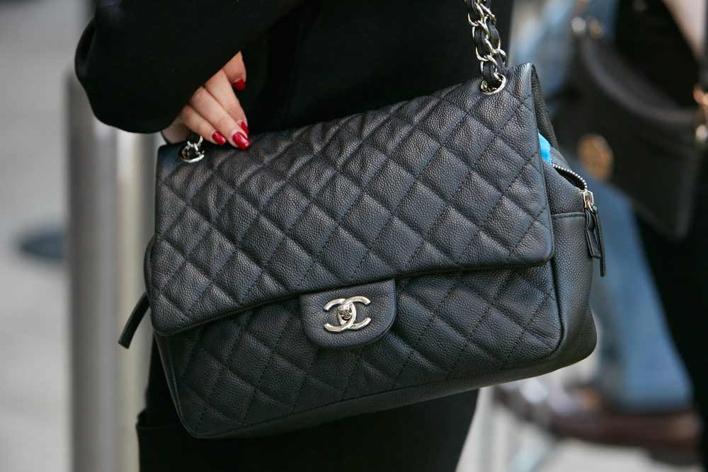 Kvinde med sort Chanel-taske og røde negle