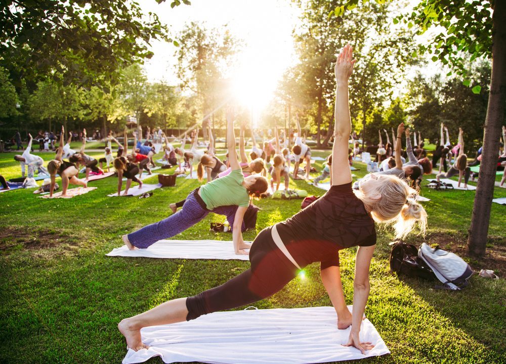 En gruppe mennesker dyrker yoga i en park