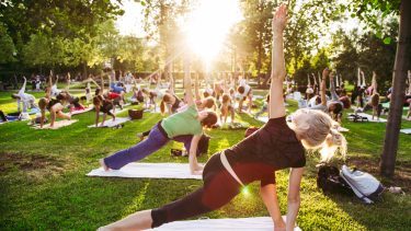 En gruppe mennesker dyrker yoga i en park