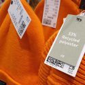 Orange tøj af genbrugspolyester hænger på stativ