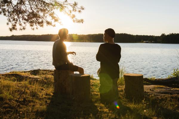 venner taler sammen ved sø