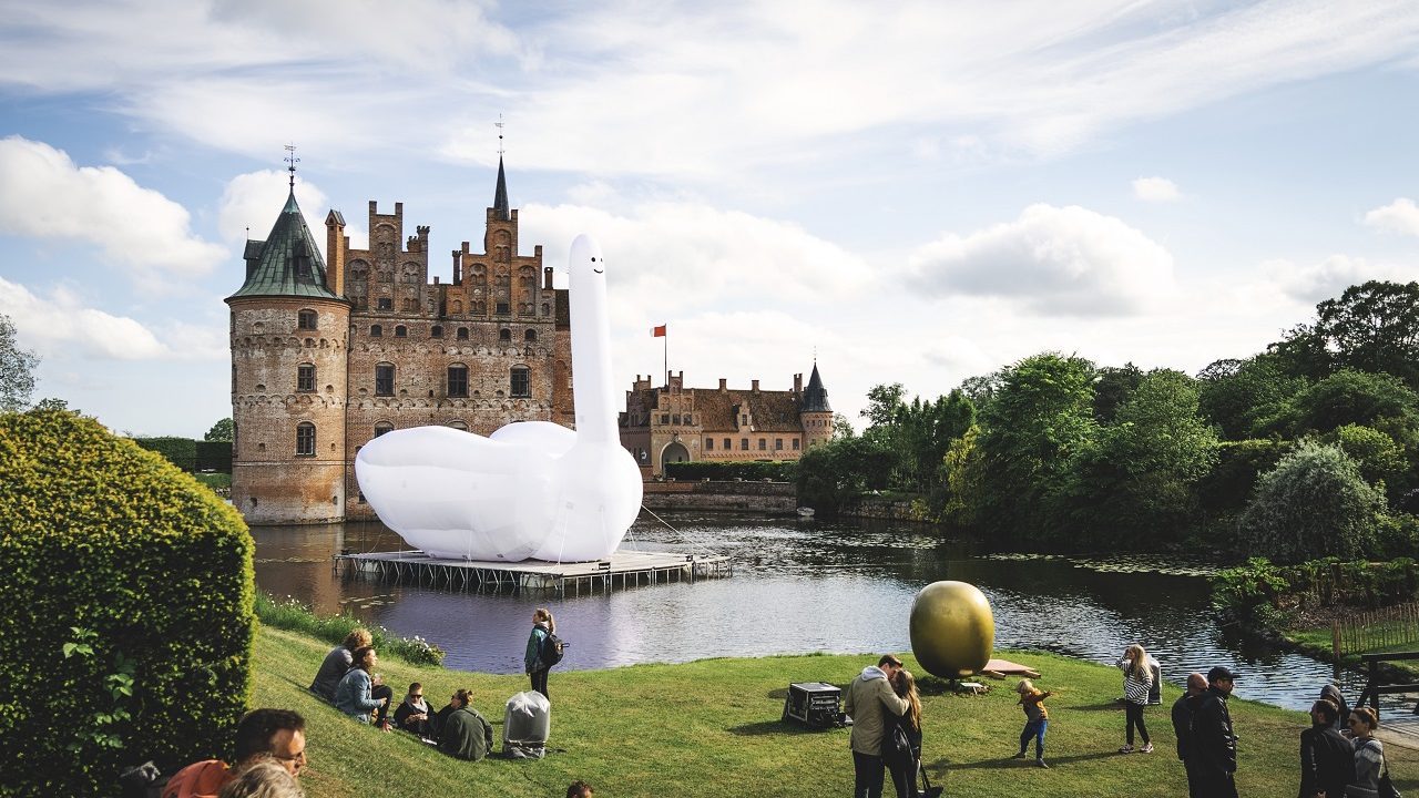 Billede fra festivalen Heartland, hvor festivalgæster slapper af foran Egeskov Slot.