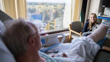 En gammel mand med et brækket ben får besøg af sit barnebarn