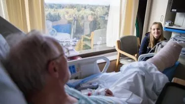 En gammel mand med et brækket ben får besøg af sit barnebarn