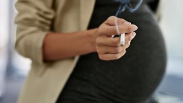 Højgravid kvinder der ryger en cigaret