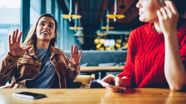 To kvinder taler sammen i café