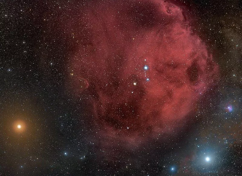 Stjernerne i stjernebilledet Orion lyser kraftigt gennem en rød stjernetåge på nattehimlen - en af dem er Betelgeuse.