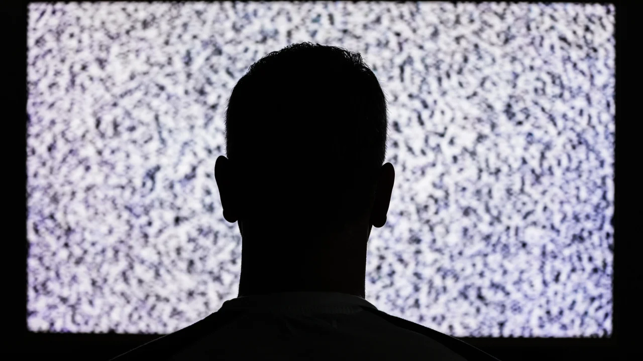 mand sidder foran tv uden signal