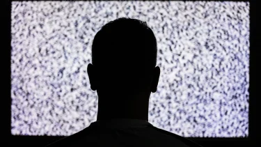 mand sidder foran tv uden signal