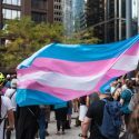 Stort transkønnet pride-flag vejrer over en demonstration i USA