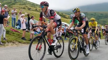 Mikkel Bjerg med tungen ud af munden i Tour de France 2023, Vingegaard ses i baggrunden