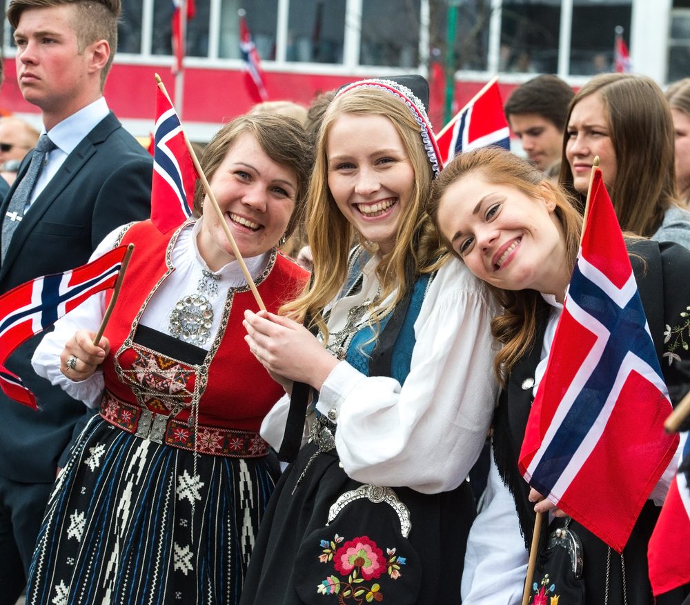Norske kvinder står med flag i nationaldragter