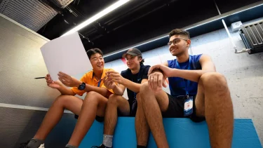 Tre unge mænd sidder på LIFE Fondens campus