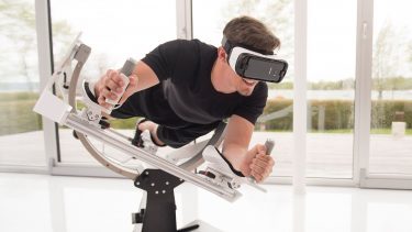 Mand liggende på Icaros VR-træningsmaskine