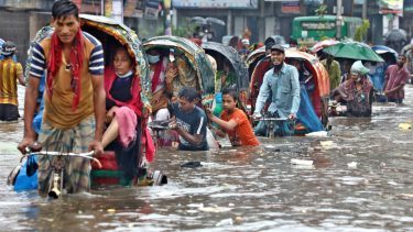 Bangladesh: En række cykeltaxaer kæmper sig gennem hvad der ligner 70-80 centimeters vand.