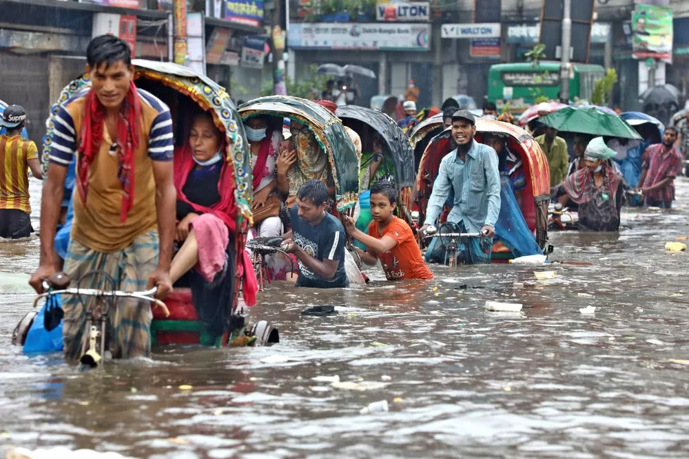 Bangladesh: En række cykeltaxaer kæmper sig gennem hvad der ligner 70-80 centimeters vand.
