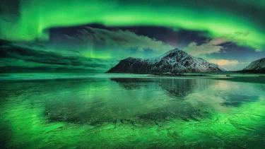 nordlys i en stor cirkel på himlen spejlet i vandet