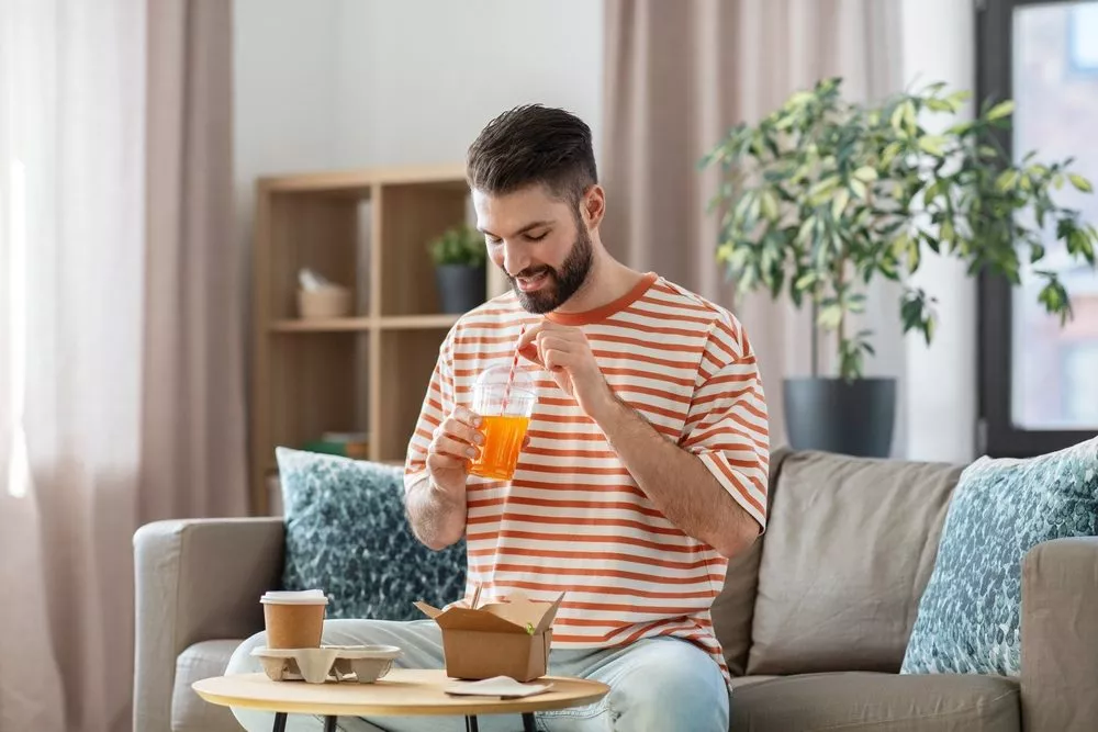 Mand med papirsugerør i drink