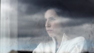 Kvinde kigger ud af vinduet