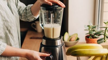 Kvinde laver smoothie i blender