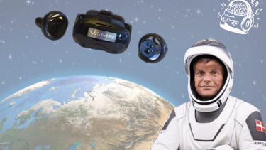 Andreas Mogensen i astronautdragt står foran Jorden og VR-briller svæver i luften over ham