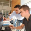 lærer hjælper ung studerende ved computer