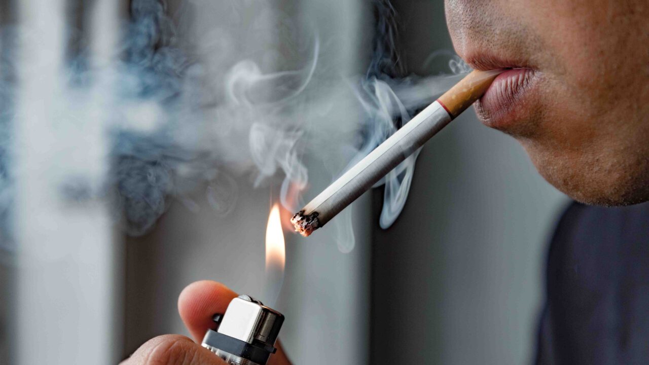 mand der tænder en cigaret