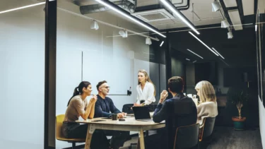 mennesker arbejder rundt om et bord på et kontor