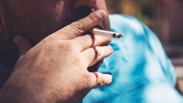 Overvægtig mand ryger cigaret