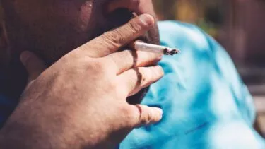 Overvægtig mand ryger cigaret